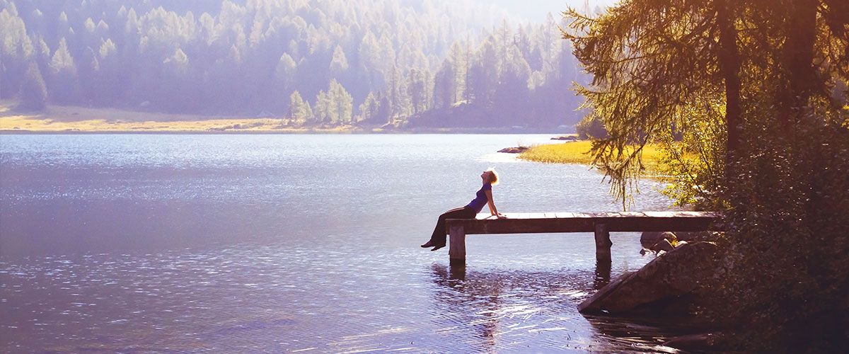 Frau sitzt auf einem Steg